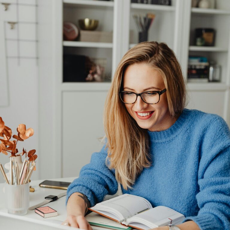 Smiling woman working on laptop with headphones